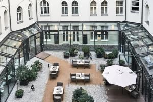 Elle offre une vue sur la terrasse dotée de tables et d'un parasol. dans l'établissement Hotel am Steinplatz, Autograph Collection, à Berlin