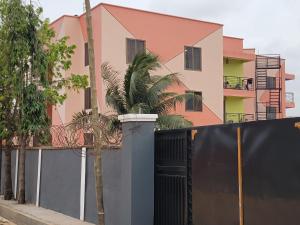 a house with a black fence and a palm tree at VaQ Apartments in Spintex