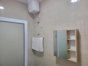 een badkamer met een spiegel en een handdoek bij VaQ Apartments in Spintex
