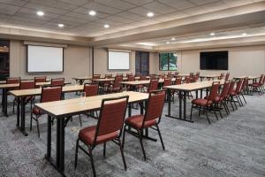 a conference room with tables and chairs and a screen at Courtyard by Marriott Denver Airport in Denver