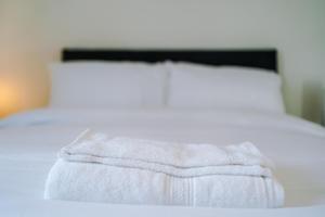 Una cama con una manta blanca encima. en Videl Homes, en Mánchester