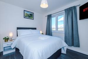 a bedroom with a white bed and a window at Videl Homes in Manchester