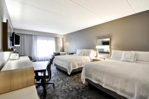道尔顿Courtyard by Marriott Dalton的有两张床和一张书桌的酒店房间