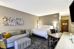 a hotel room with a bed and a couch at Courtyard by Marriott Dalton in Dalton