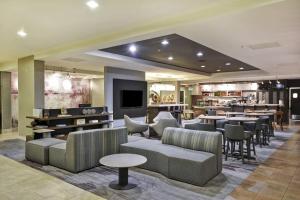 a hotel lobby with tables and chairs and a bar at Courtyard by Marriott Dalton in Dalton