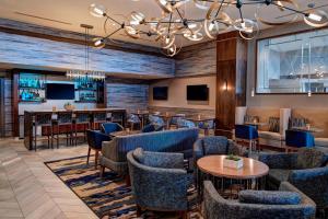 um restaurante com mesas e cadeiras e um bar em Auburn Hills Marriott Pontiac em Pontiac