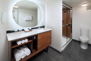 a bathroom with a sink and a mirror at The Laylow, Autograph Collection in Honolulu