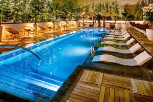 a swimming pool with lounge chairs in a hotel at The Laylow, Autograph Collection in Honolulu