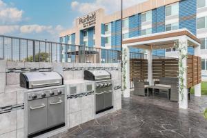 an outdoor kitchen with a grill in front of a building at Fairfield by Marriott Inn & Suites Amarillo Central in Amarillo