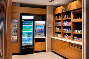eine Getränkestation mit Kühlschrank und Regalen in der Unterkunft SpringHill Suites by Marriott Tampa Suncoast Parkway in Land O' Lakes