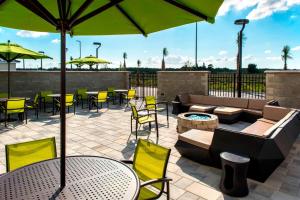 a patio with tables and chairs and an umbrella at SpringHill Suites by Marriott Tampa Suncoast Parkway in Land O' Lakes