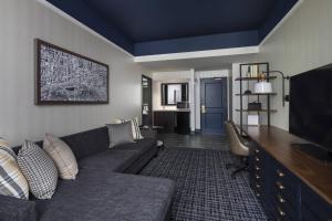 a living room with a couch and a flat screen tv at The Notary Hotel, Philadelphia, Autograph Collection in Philadelphia