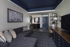 a living room with a couch and a flat screen tv at The Notary Hotel, Philadelphia, Autograph Collection by Marriott in Philadelphia
