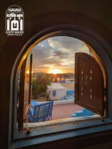 an arched window with a view of a sunset at Kato Waidi Nubian Resort in Aswan