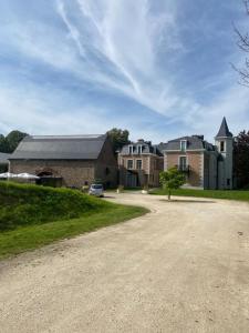 un gran edificio de ladrillo con un coche aparcado en la entrada en La chambre et le studio du château du golf de Bernalmont en Lieja