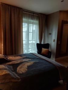 a bedroom with a large bed and a window at La chambre et le studio du château du golf de Bernalmont in Liège