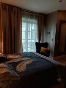 - une chambre avec un grand lit et une fenêtre dans l'établissement La chambre et le studio du château du golf de Bernalmont, à Liège