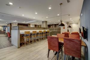 a dining room with a bar and some chairs at TownePlace Suites by Marriott Houston Hobby Airport in Houston