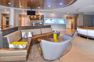 a lobby with a couch and chairs and a bar at SpringHill Suites Fairfax Fair Oaks in Fairfax