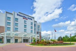 un bâtiment arborant un drapeau américain devant lui dans l'établissement SpringHill Suites Fairfax Fair Oaks, à Fairfax