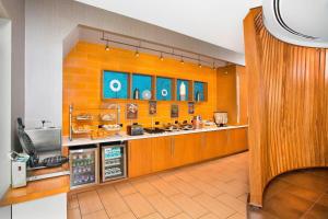 a large kitchen with orange walls and a counter at SpringHill Suites Fairfax Fair Oaks in Fairfax
