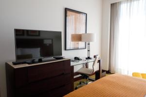 a bedroom with a bed and a desk with a television at Bogotá Marriott Hotel in Bogotá