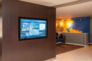 a flat screen tv on a wall in a lobby at Courtyard Chicago Glenview/Northbrook in Glenview