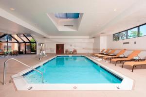 a pool in a hotel with chairs and a swimming pool at Courtyard Chicago Glenview/Northbrook in Glenview