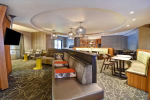 ケネソーにあるSpringHill Suites by Marriott Atlanta Kennesawのホテルのロビーにはバーとテーブルがあります。