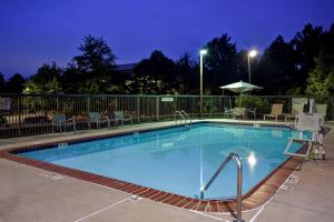 una gran piscina por la noche con mesas y sillas en SpringHill Suites by Marriott Atlanta Kennesaw, en Kennesaw