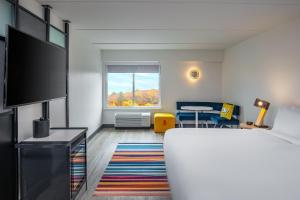 a hotel room with a bed and a table at Aloft Framingham in Framingham