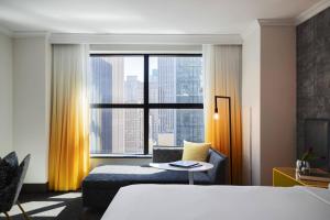 a hotel room with a bed and a large window at Renaissance New York Times Square Hotel by Marriott in New York
