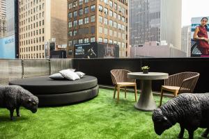 two sheep on a rooftop with a table and chairs at Renaissance New York Times Square Hotel by Marriott in New York