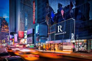 una concurrida calle de noche con coches y edificios en Renaissance New York Times Square Hotel by Marriott en Nueva York