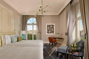 a bedroom with a white bed and a desk and a table at The Ritz-Carlton, Budapest in Budapest