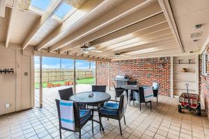 a patio with a table and chairs and a brick wall at Dolphin Lodge in Galveston