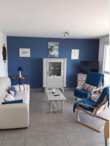 ein Wohnzimmer mit blauen Wänden und weißen Möbeln in der Unterkunft appartement entier, 3 étoiles, 4 personnes,vue mer in Audierne