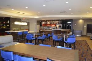 a restaurant with blue chairs and tables and a bar at Courtyard by Marriott Winchester Medical Center in Winchester