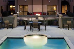 a pool with chairs and a table in a building at Courtyard by Marriott Jackson Ridgeland in Jackson