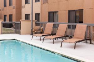 un patio con sillas y una piscina en Courtyard by Marriott Jackson Ridgeland, en Jackson