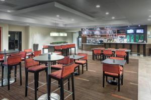 a restaurant with tables and chairs and a bar at Courtyard by Marriott Jackson Ridgeland in Jackson