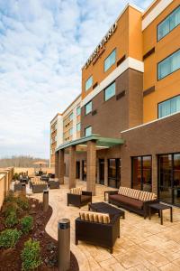 a hotel with benches outside of a building at Courtyard by Marriott Stafford Quantico in Triangle