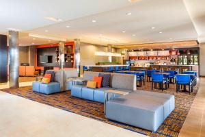 um átrio do hotel com cadeiras e mesas e um bar em Courtyard by Marriott Stafford Quantico em Triangle