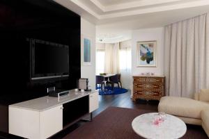 فندق مريديان الخبر في الخبر: غرفة معيشة مع تلفزيون وأريكة وطاولة