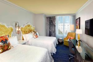 チャールストンにあるGrand Bohemian Hotel Charleston, Autograph Collectionのベッド2台とテレビが備わるホテルルームです。