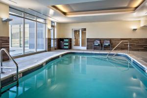 Fairfield Inn & Suites by Marriott Fayetteville في فايتيفيل: حمام سباحة بمياه زرقاء في غرفة في الفندق