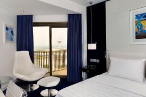 a hotel room with a bed and a balcony at Le Meridien Al Khobar in Al Khobar