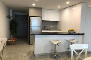 a kitchen with a counter with stools and a refrigerator at Apartamento en Torres del Sun Rise San Andres Islas Colombia in San Andrés