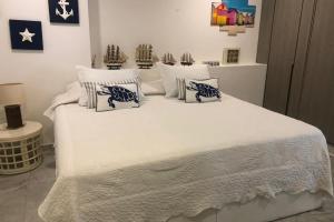 a bedroom with a white bed with pillows at Apartamento en Torres del Sun Rise San Andres Islas Colombia in San Andrés +6 photos