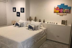 a bedroom with a bed with white sheets and pillows at Apartamento en Torres del Sun Rise San Andres Islas Colombia in San Andrés